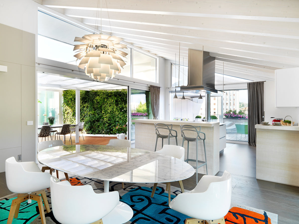 Sala da pranzo e cucina in open space con grandi vetrate verso gli spazi esterni e interior design contemporaneo
