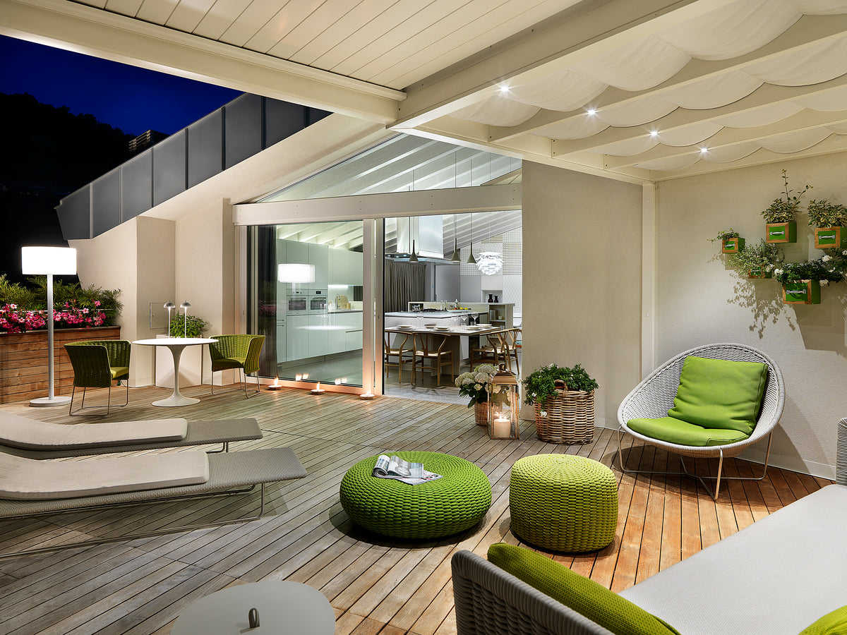 Spazio esterno con deck in legno, sedute relax e continuità tra indoor e outdoor