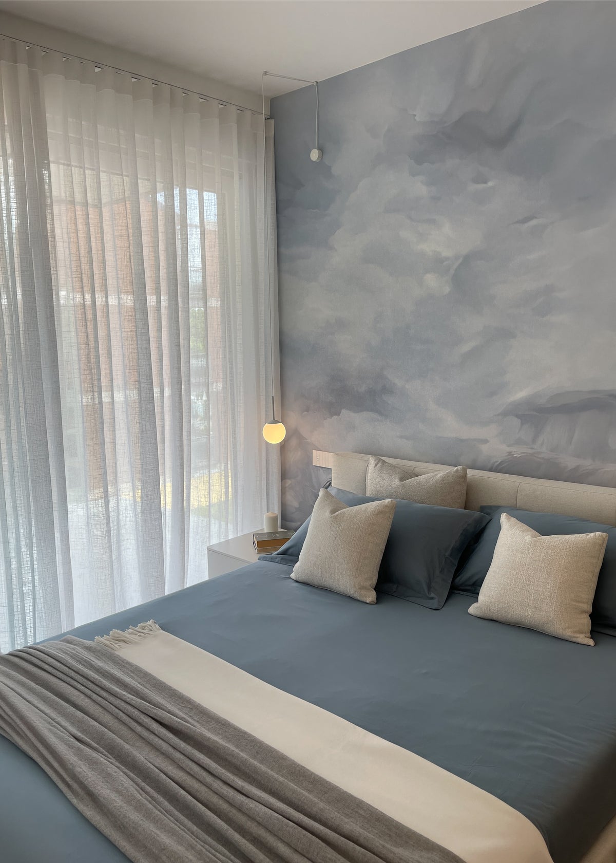 Progettazione della zona notte di un attico sul Lago di Garda con camera luminosa, carta da parati decorata e arredi su misura