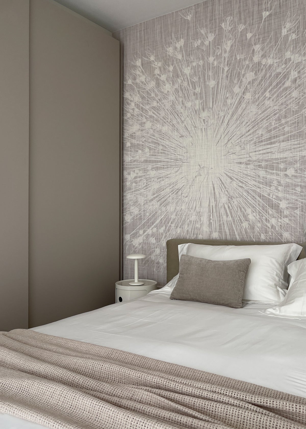 Interior design della seconda camera da letto con carta da parati decorativa, letto imbottito e arredi dai toni neutri