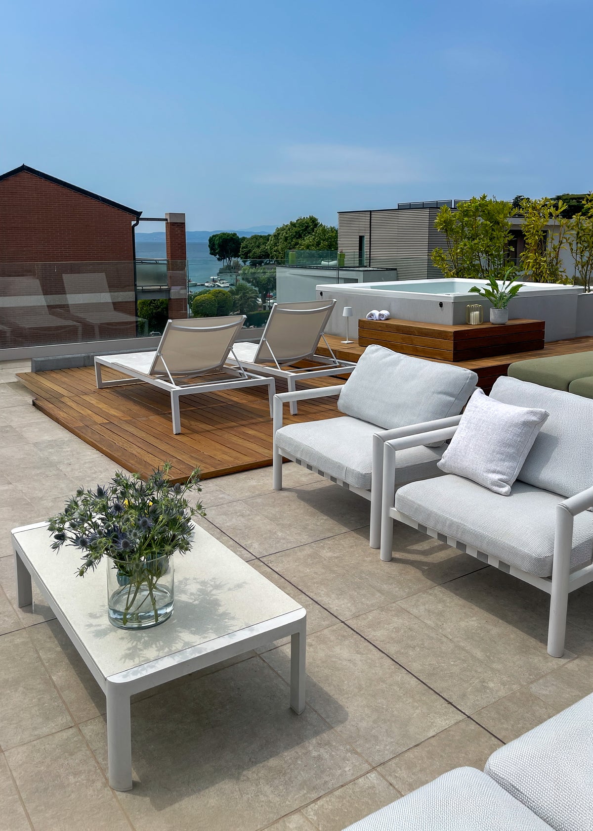 Progettazione degli spazi outdoor di un attico sul Lago di Garda con salotto, area relax e mini piscina idromassaggio Novellini