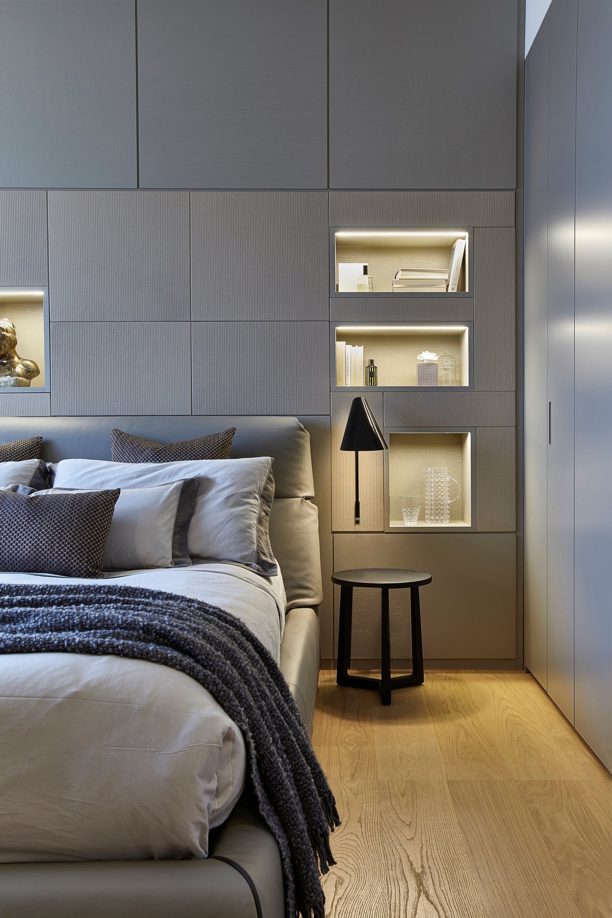 Camera matrimoniale dal design contemporaneo con boiserie realizzata su misura e illuminazione architettonica