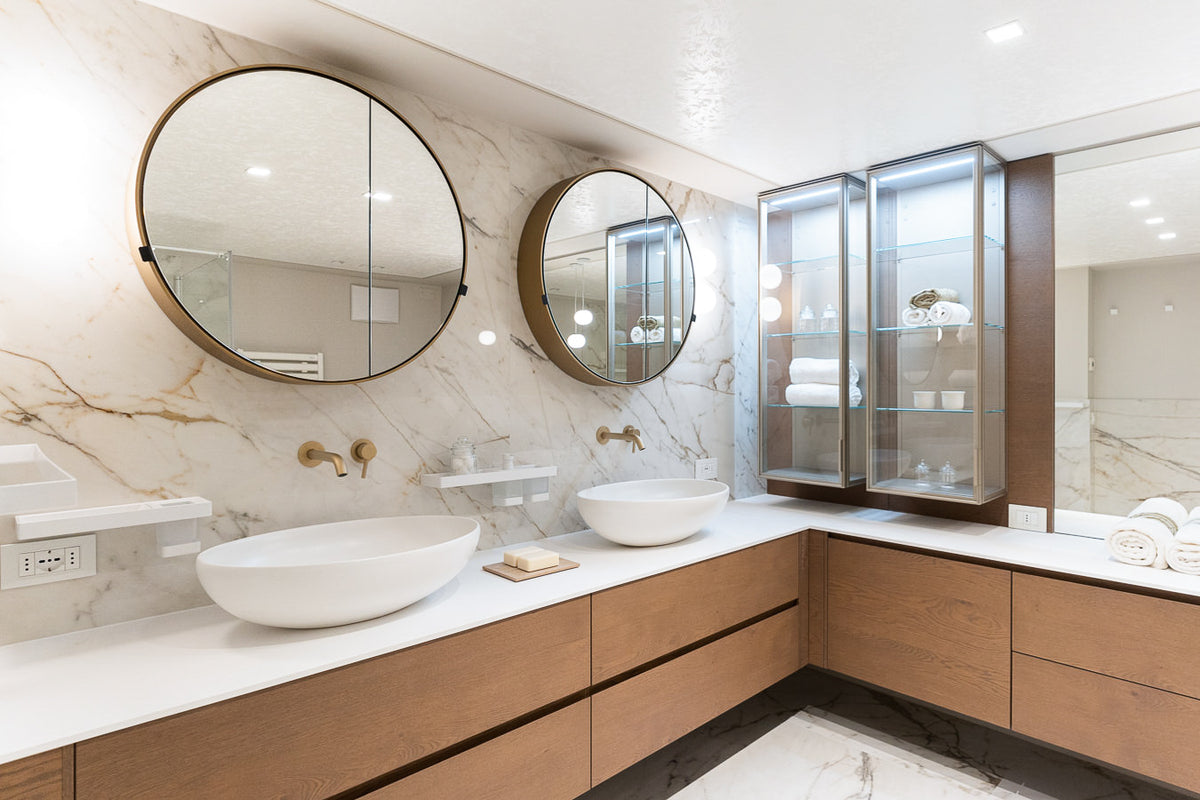 Bagno padronale con doppio lavabo e specchi rotondi, arredamento su misura