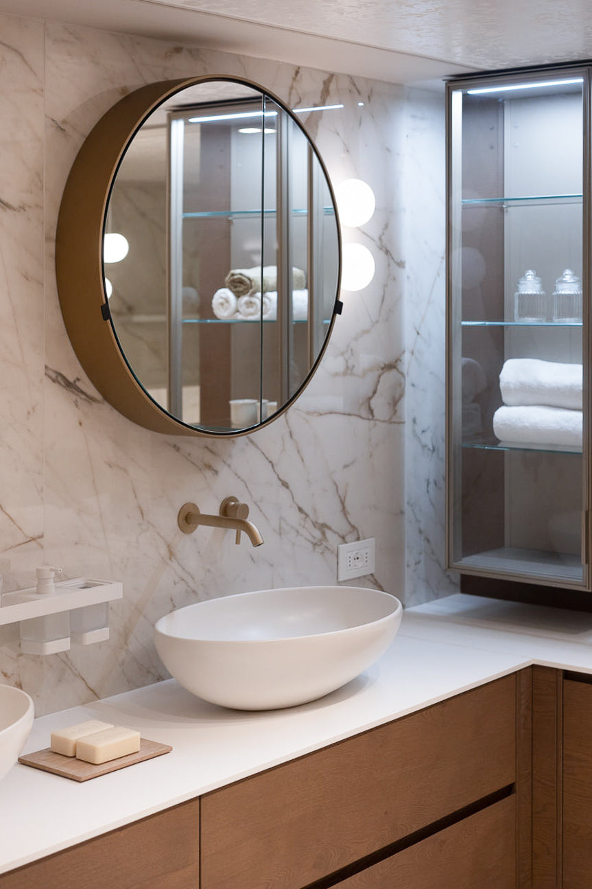 Dettaglio lavabo con rubinetteria bronzata e piano in marmo