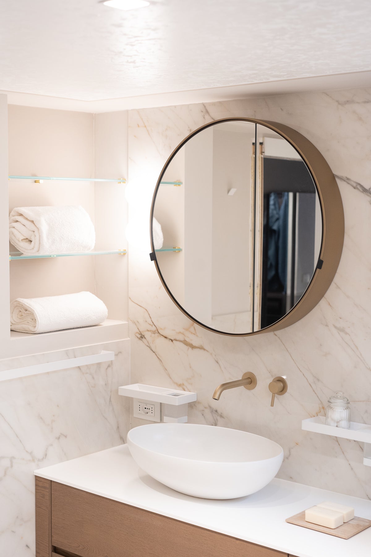 Lavabo con specchio rotondo e rivestimento in marmo