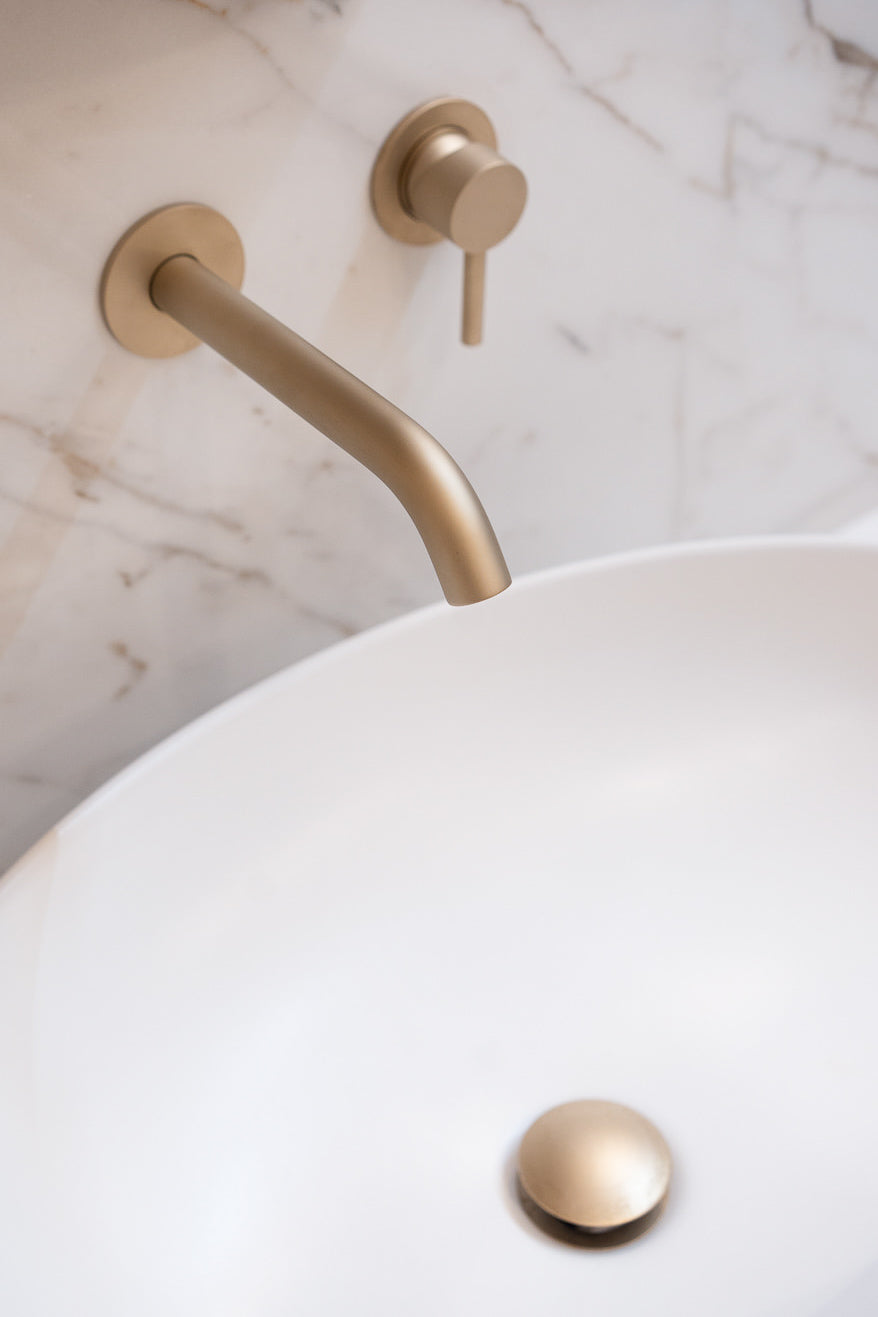 Dettaglio della rubinetteria bronzata su lavabo da appoggio 