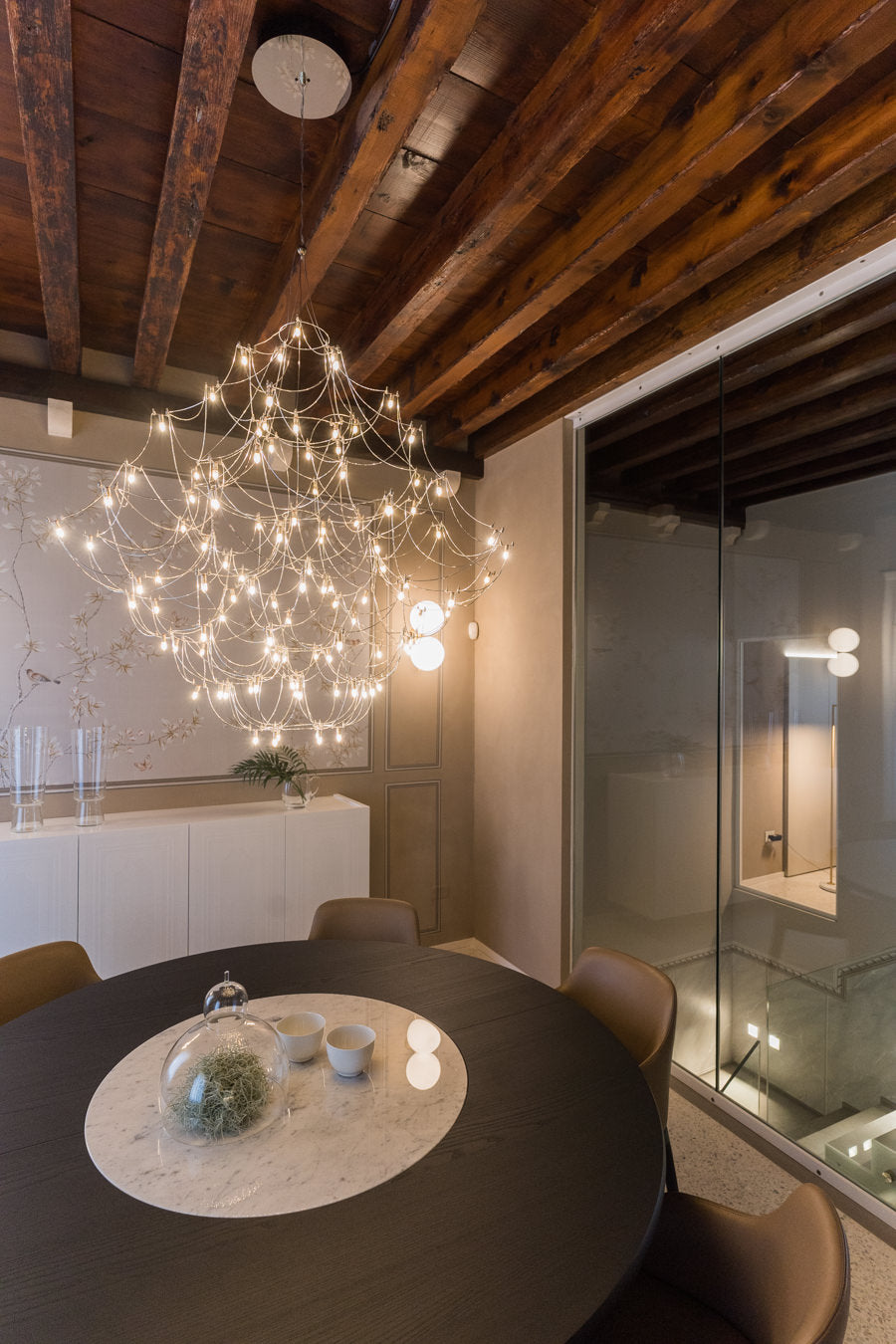 Zona pranzo con lampadario scenografico e dialogo tra classico e contemporaneo