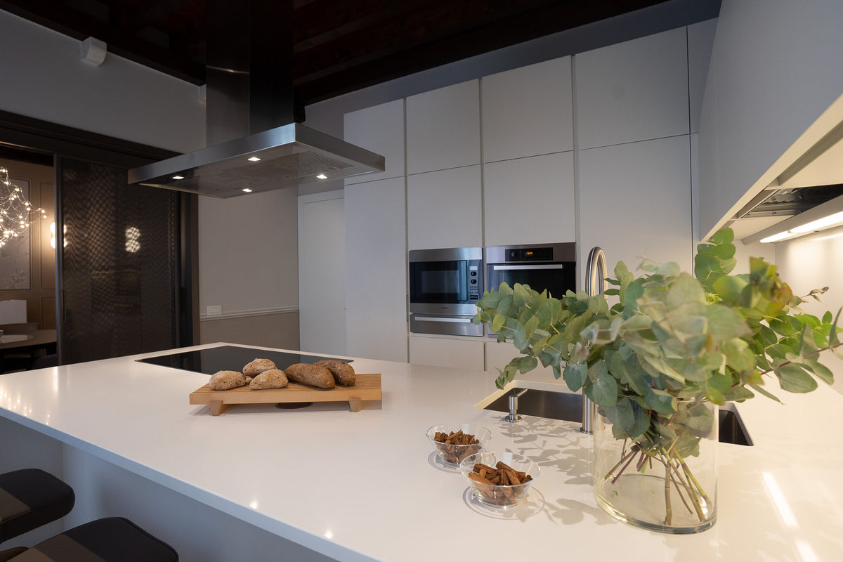 Cucina con sgabelli, piano snack e progetto su misura dal carattere essenziale