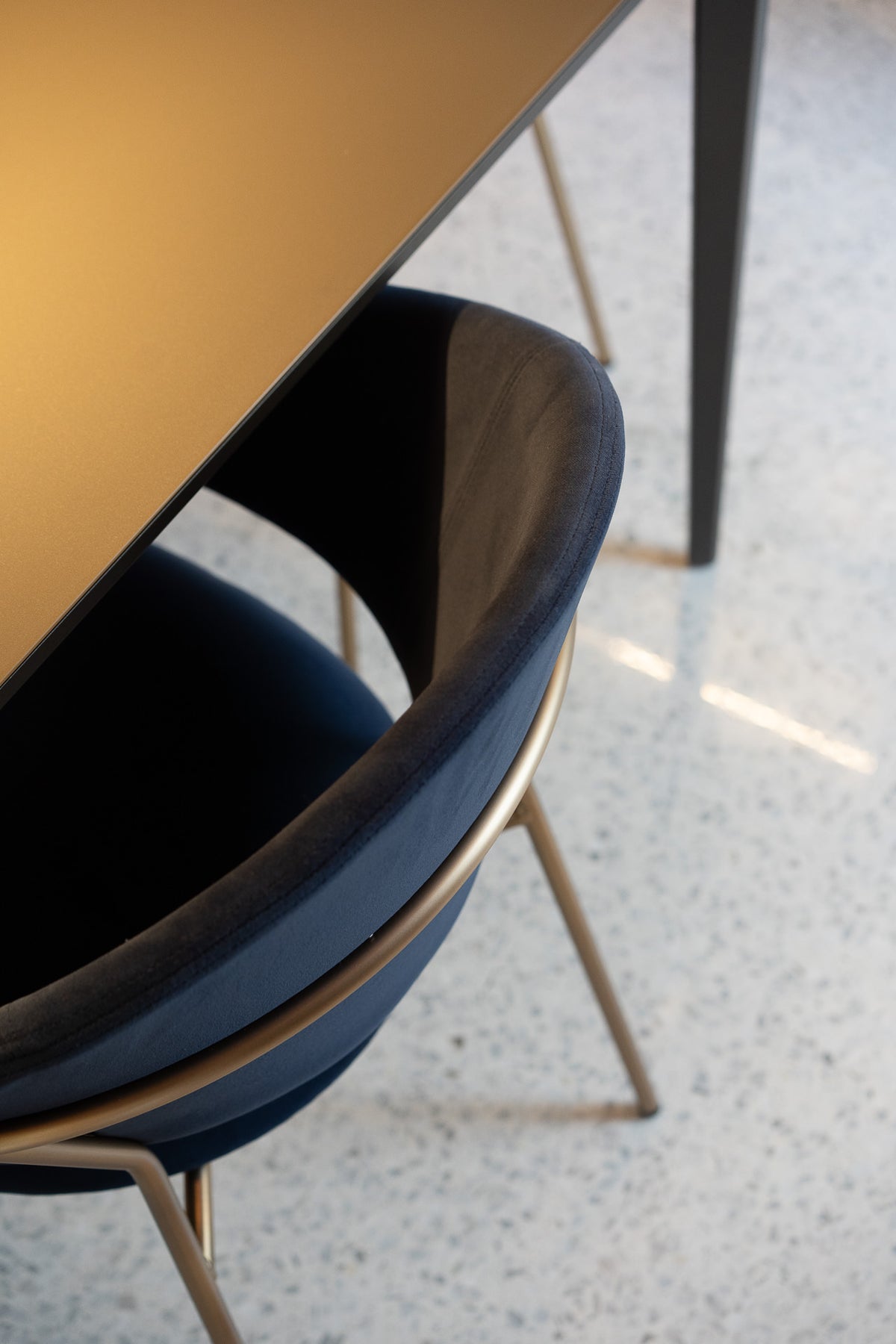 Dettaglio della sedia blu con struttura curva nella zona pranzo