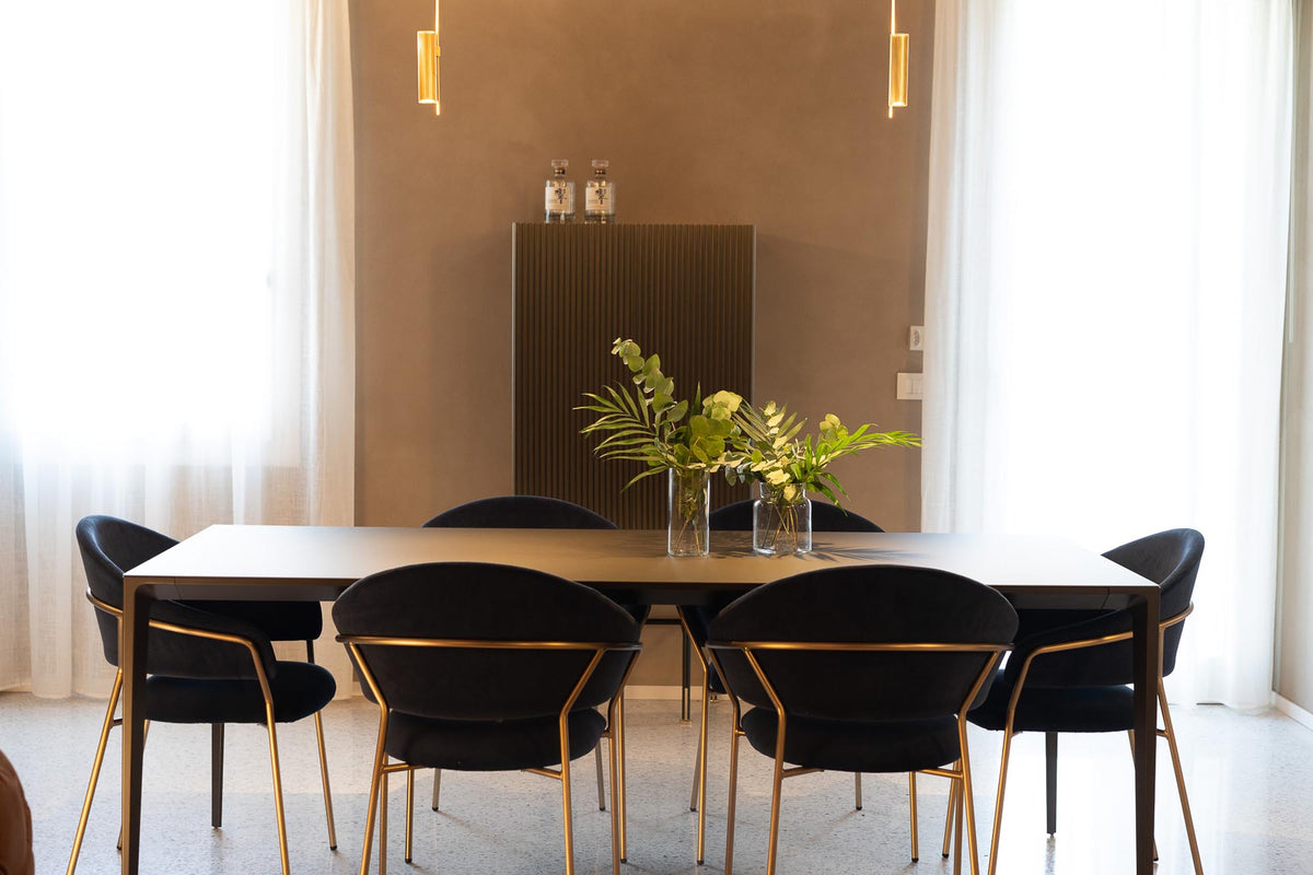 Tavolo da pranzo nella zona giorno con sedute blu e lampada sospesa