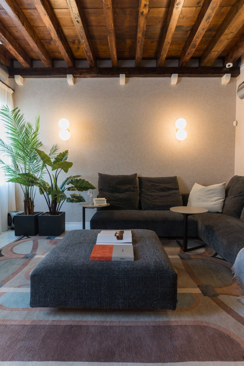 Zona relax con proiettore TV, tavolini scuri e illuminazione soffusa