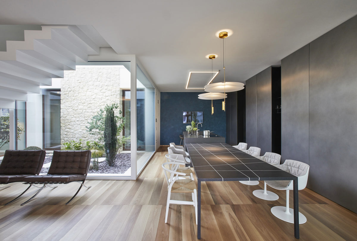 Zona giorno spaziosa con cucina, scala e area living, in progetto di interior design per una villa contemporanea