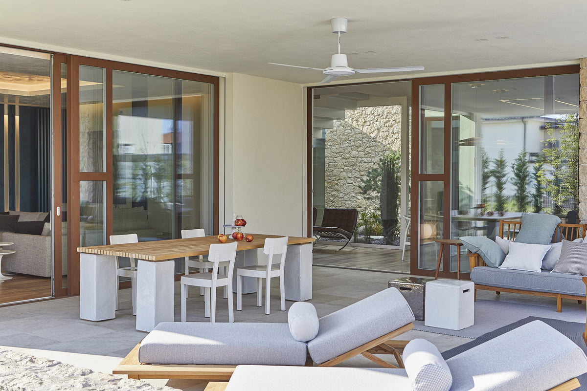 Porticato della villa con tavolo outdoor, zona lounge e serramenti scorrevoli