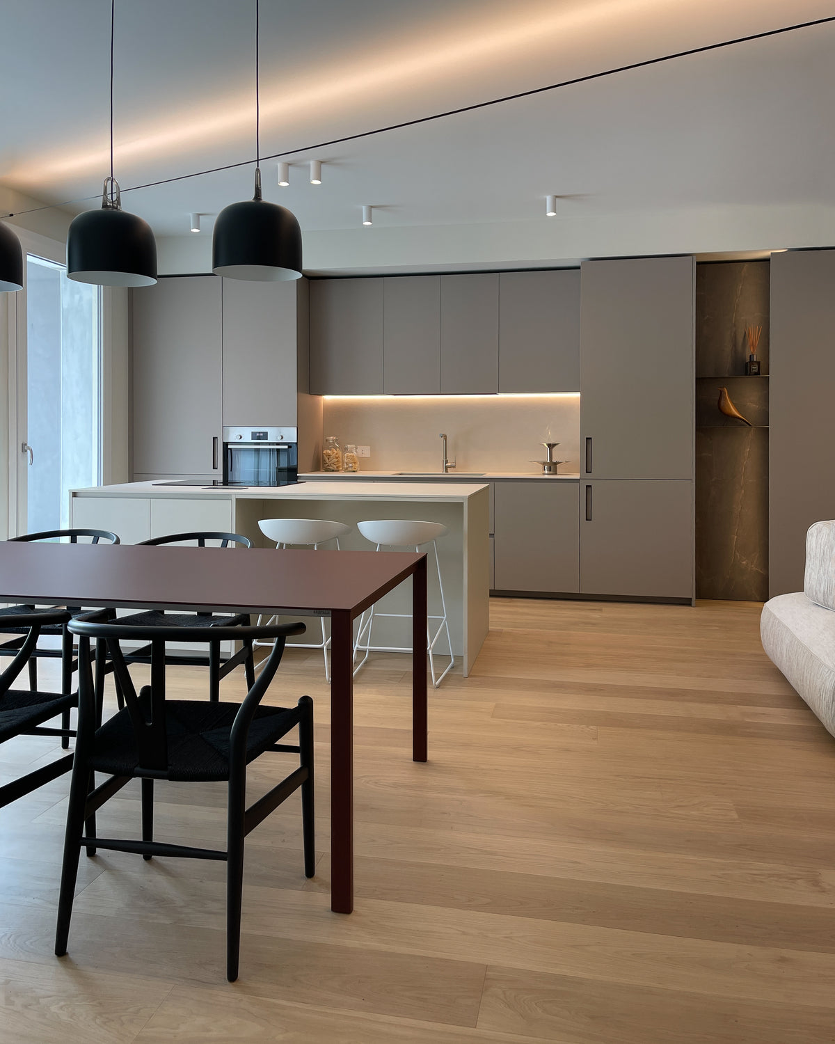 Interior design della zona giorno open space con cucina su misura, isola e zona pranzo