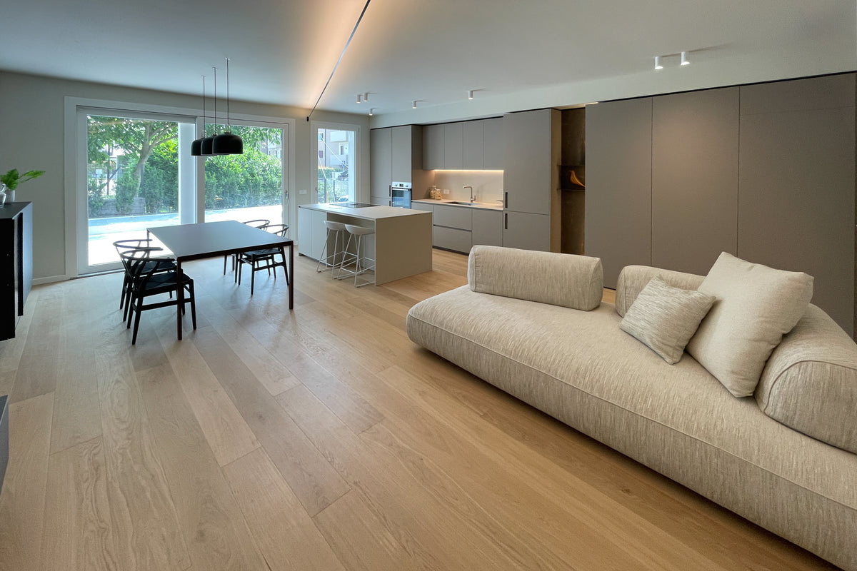 Zona giorno open space di nuova costruzione con cucina su misura, sala da pranzo, living e grandi vetrate sul giardino