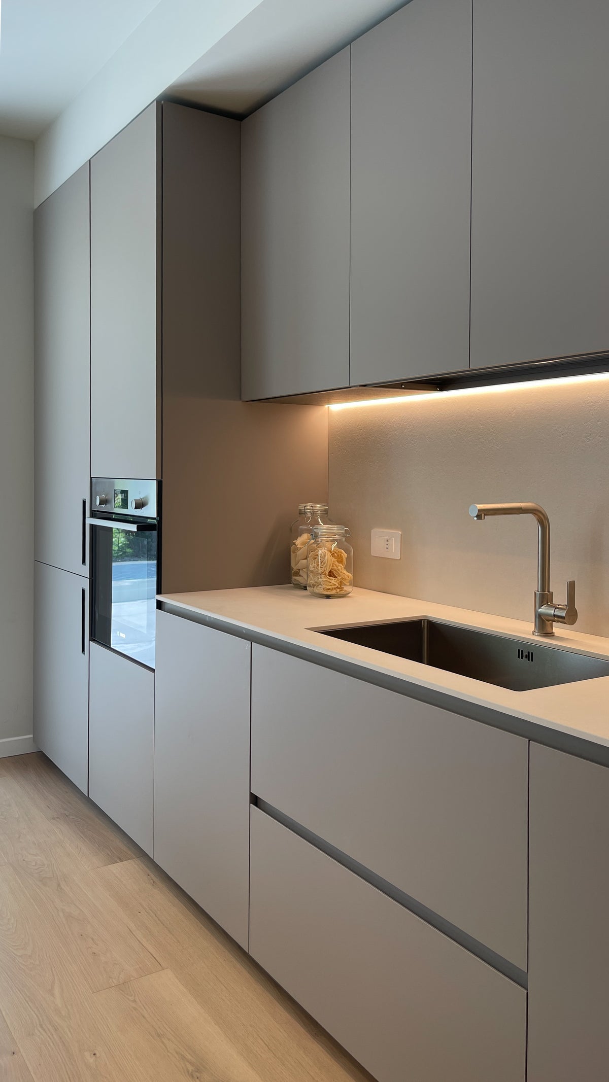 Cucina contemporanea su misura con parete attrezzata, piano di lavoro illuminato e contenimenti integrati