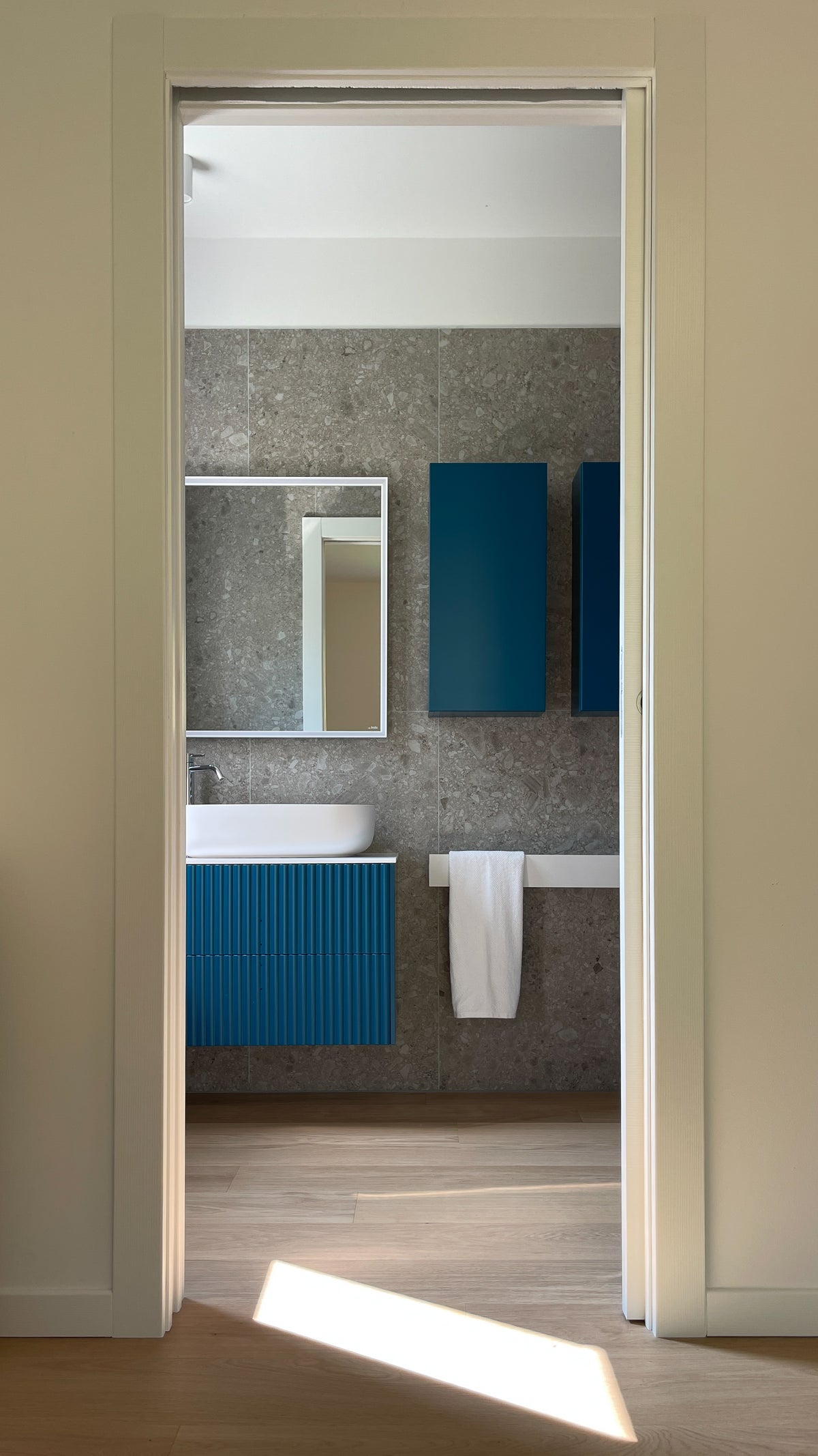 Vista del bagno contemporaneo con arredamento su misura blu ottanio e rivestimenti materici