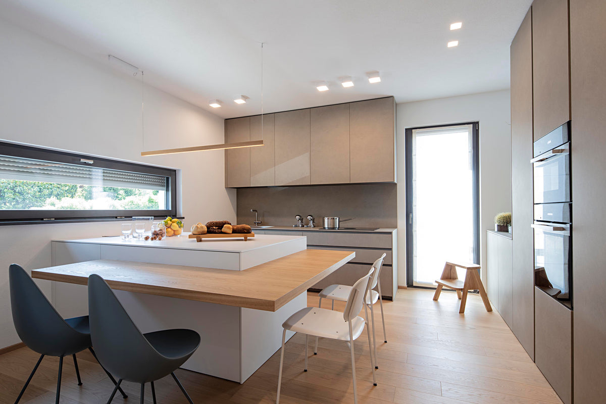 Cucina contemporanea con isola centrale e grande finestra orizzontale sul verde