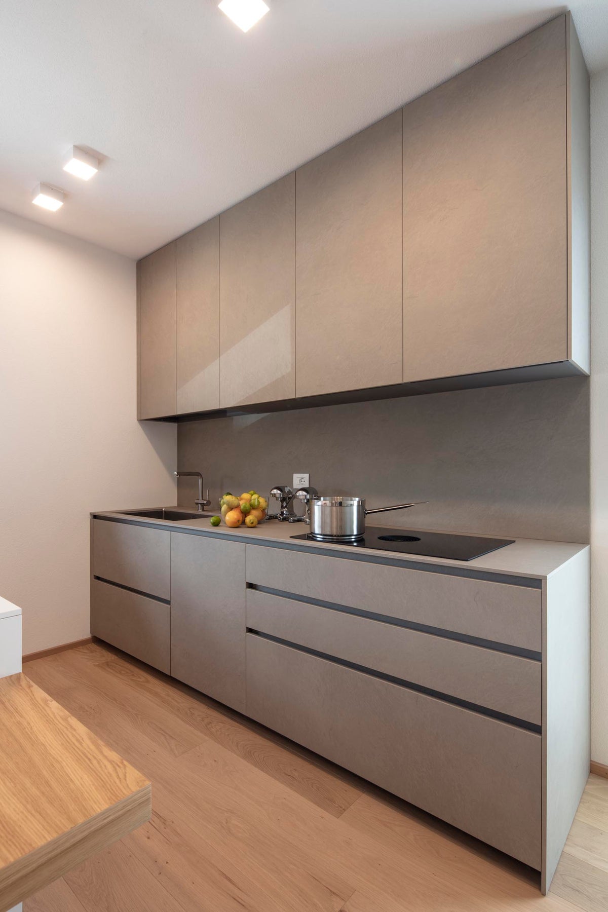 Parete cucina lineare con basi sospese e finiture nei toni del tortora