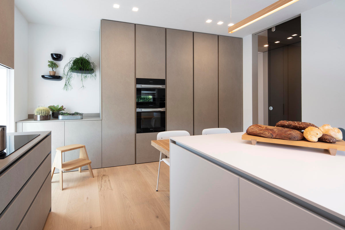 Cucina moderna con isola, colonne attrezzate e volumi essenziali