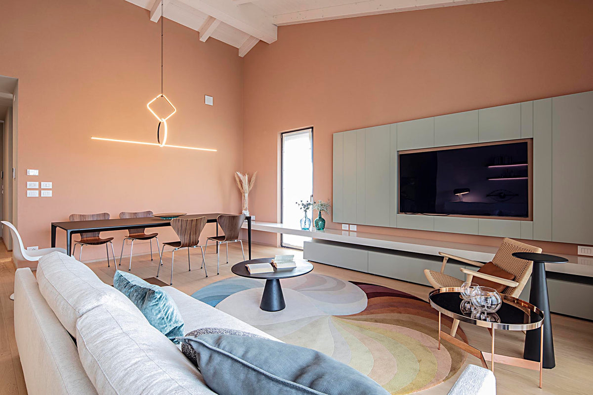 Living open space con boiserie TV e arredo su misura in dialogo con la cucina