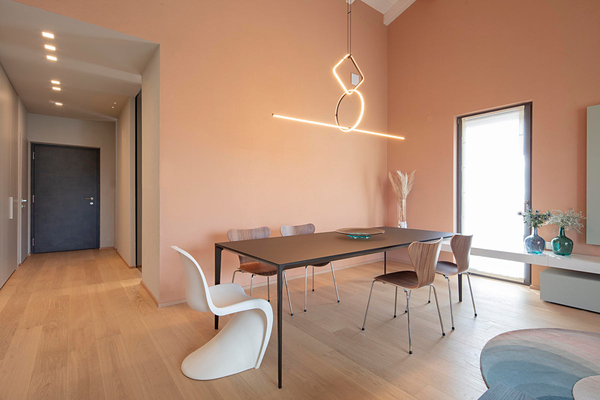 Dining contemporaneo con segno luminoso a parete e passaggio verso l’ingresso