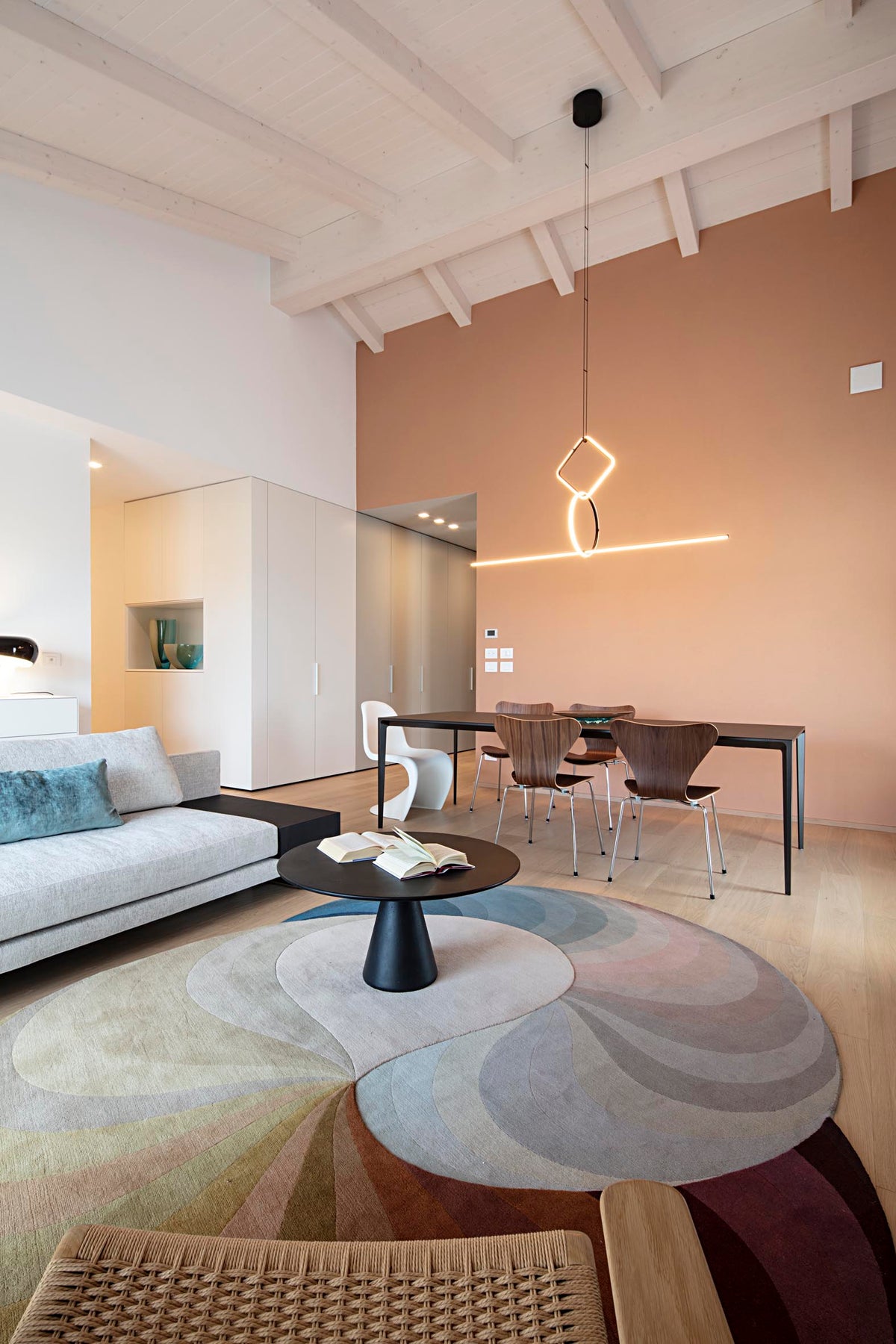Open space con living e zona pranzo sotto tetto in legno sbiancato