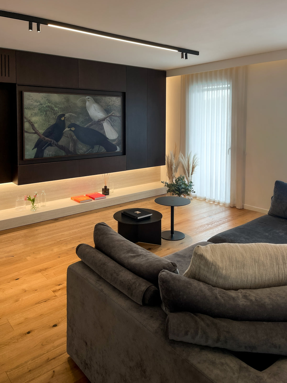Living contemporaneo con divano modulare e parete TV su misura in legno scuro con illuminazione integrata