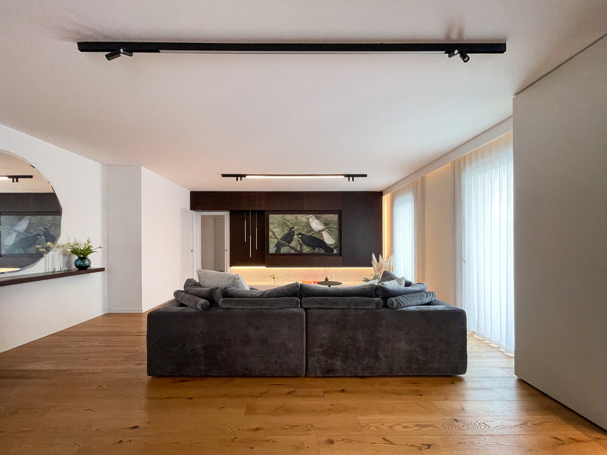Progetto di interior design della zona living con divano centrale e parete TV attrezzata su misura