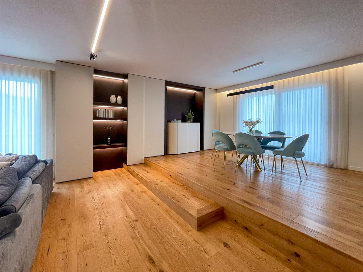 Progetto d’arredo della zona giorno con living, sala da pranzo rialzata e parete attrezzata su misura