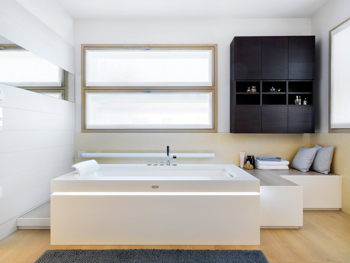 Bagno contemporaneo con vasca idromassaggio freestanding e arredo minimale con pedana e mobile sospeso