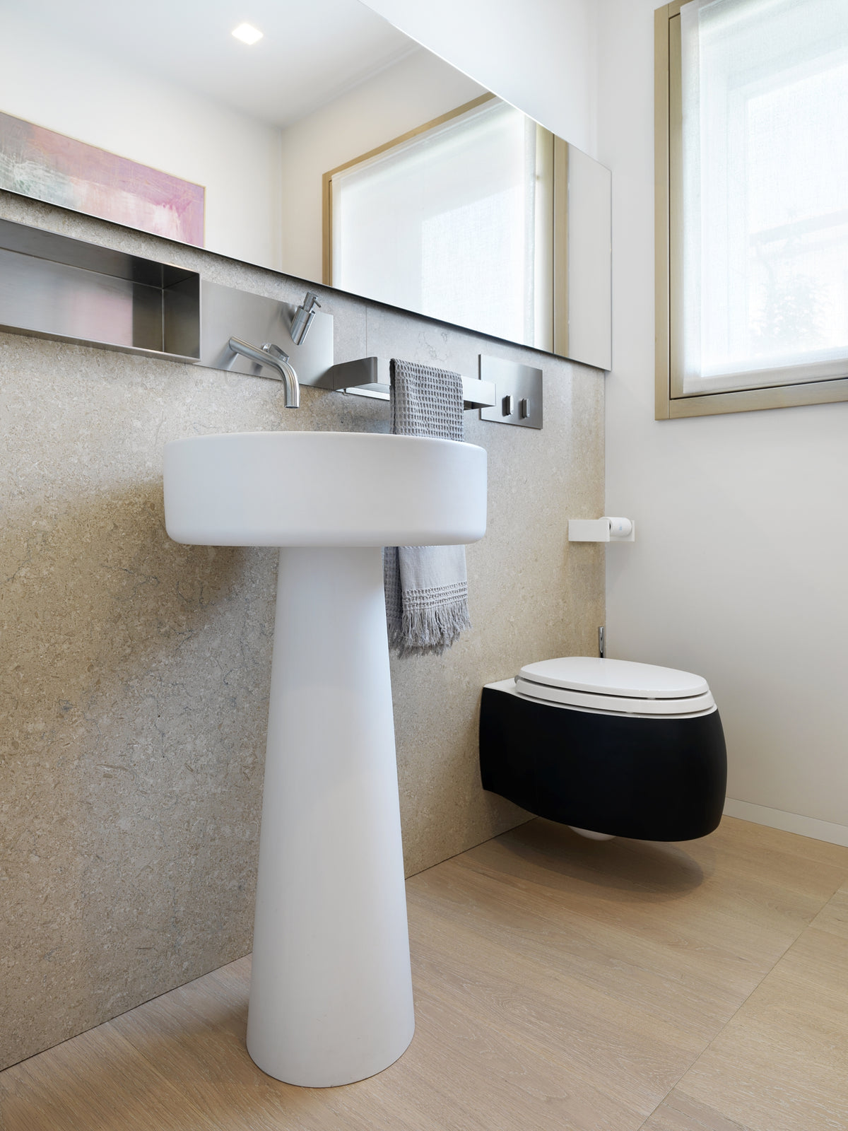 Bagno di servizio moderno con lavabo freestanding, sanitari sospesi e rubinetteria in acciaio con porta sapone integrato