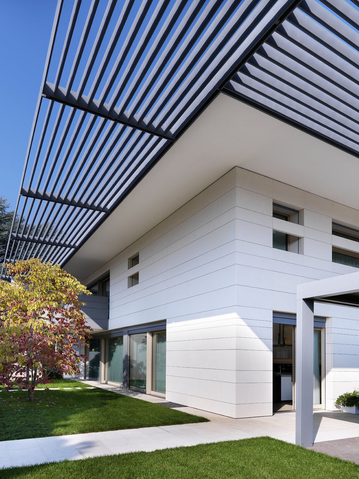 Architettura della villa contemporanea con schermature solari e giardino