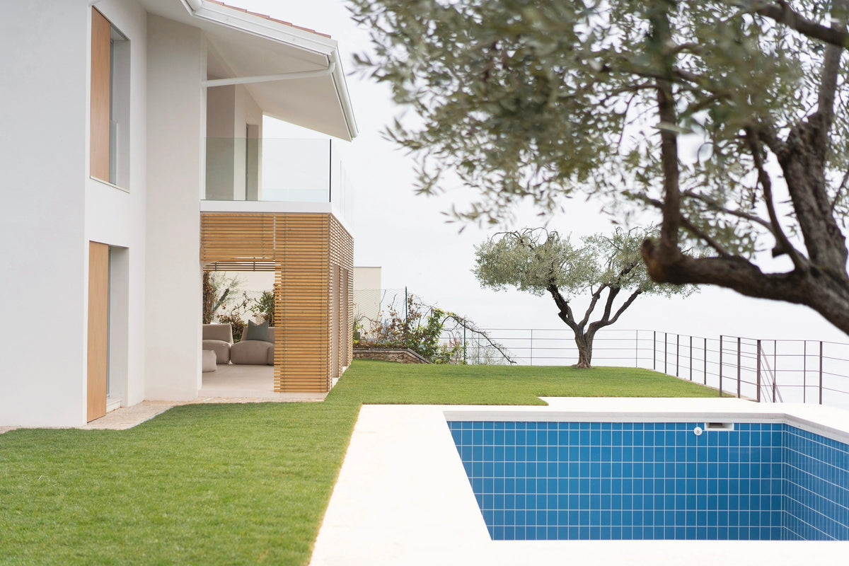 Vista del giardino con piscina e ingresso alle due unità della villa
