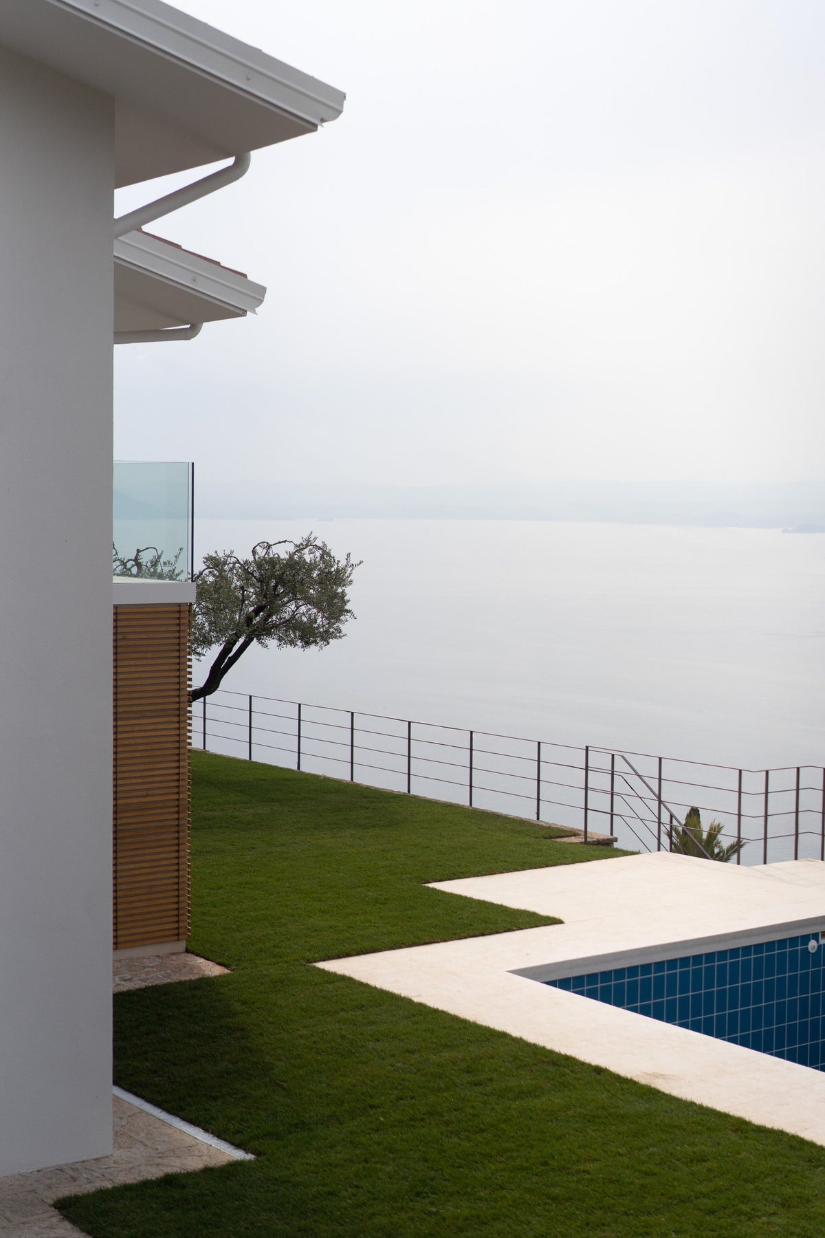 Vista laterale della piscina e del giardino affacciati sul paesaggio del Lago di Garda