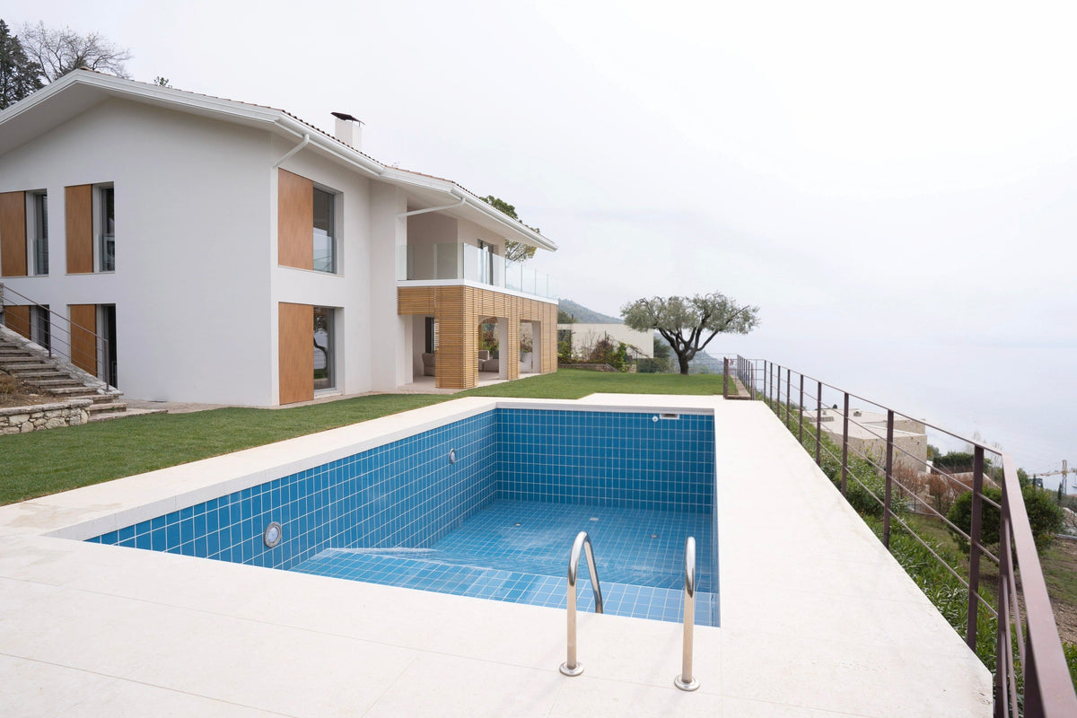 Piscina esterna con bordo lineare e villa ristrutturata sul Lago di Garda
