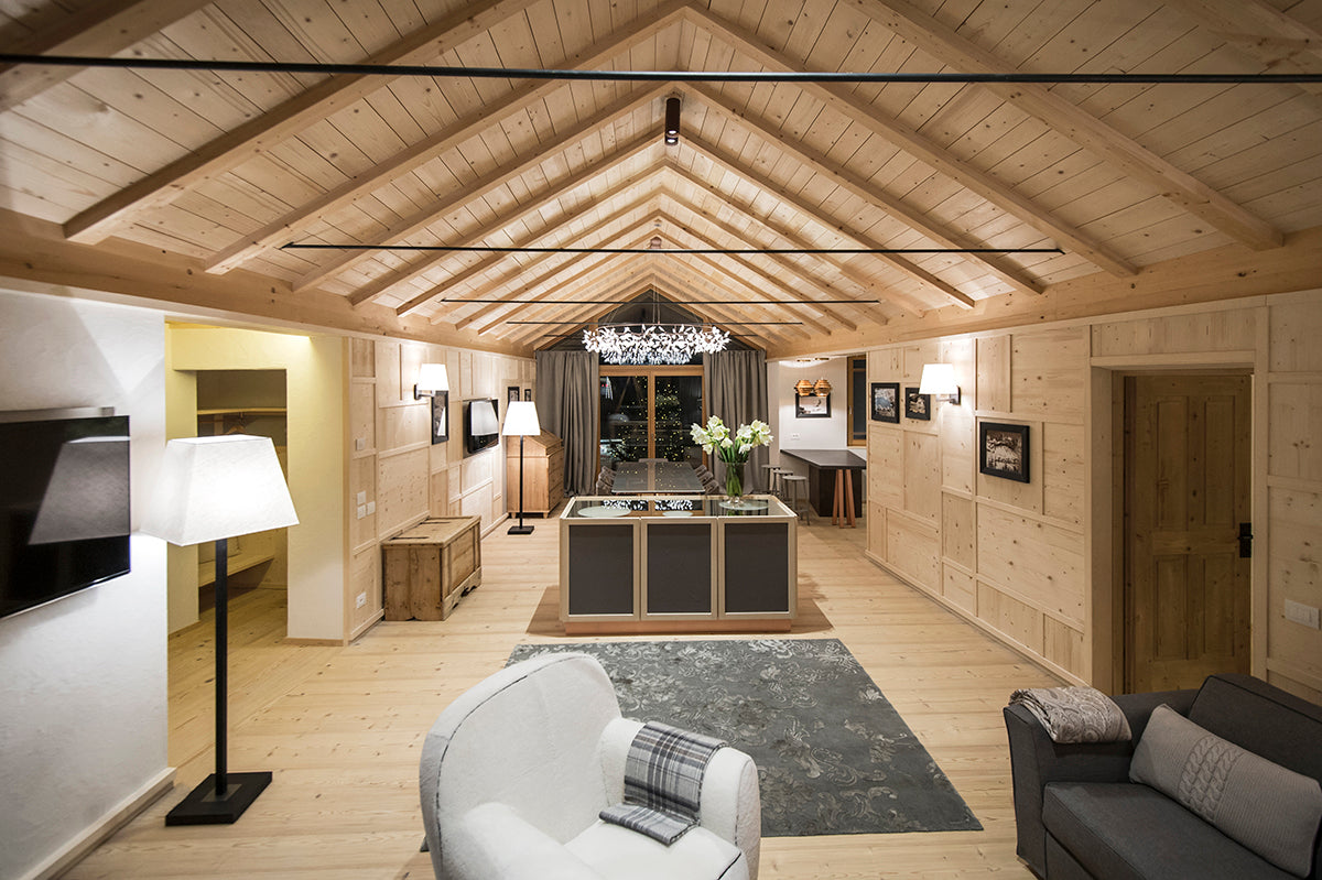 Vista completa della zona giorno dello chalet, con pareti in boiserie di legno chiaro e dettagli integrati