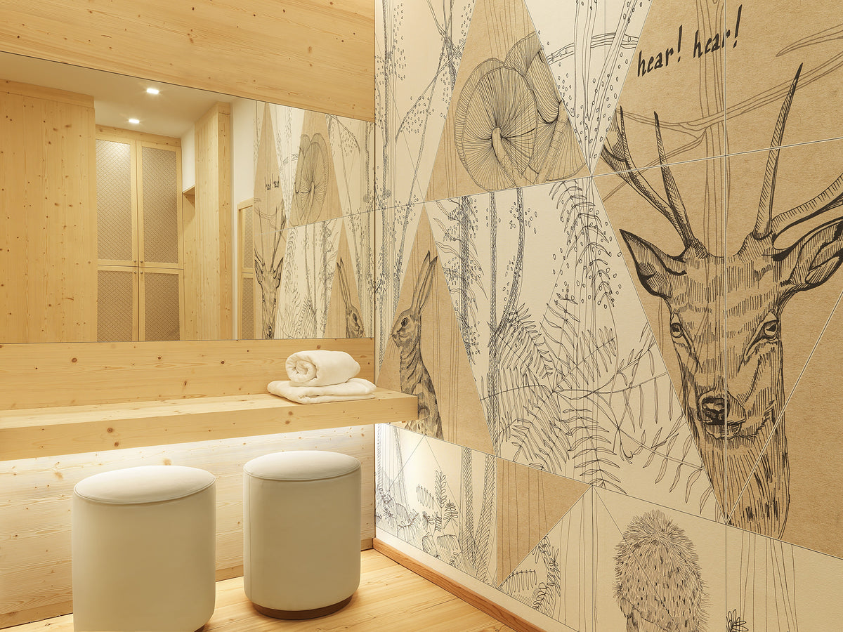 Bagno wellness con carta da parati illustrata, panca in legno e pouf cilindrici imbottiti