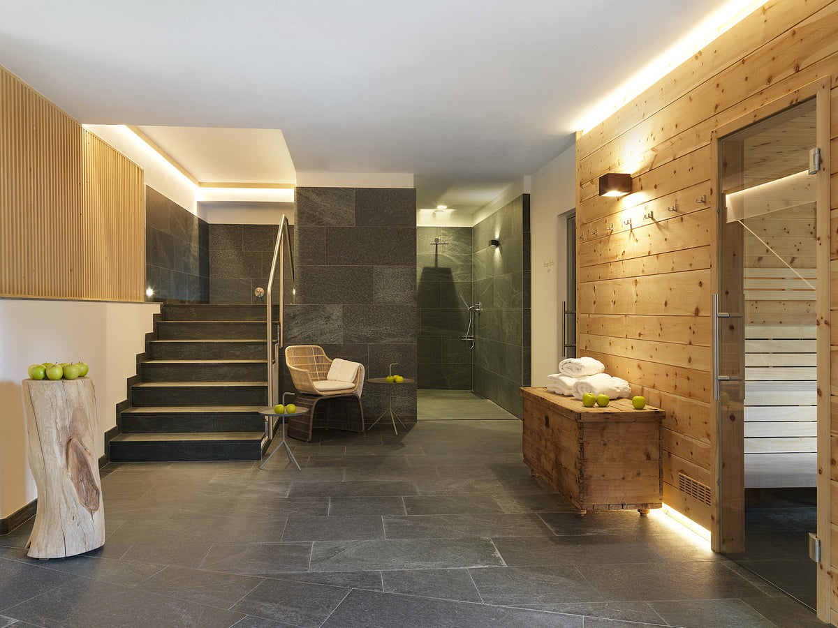 Area benessere con rivestimenti in legno e pietra, sauna, bagno turco e docce