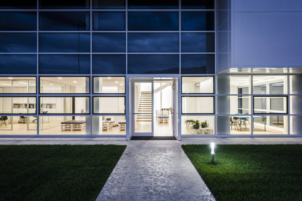 Facciata serale con illuminazione interna che evidenzia la trasparenza dell’edificio