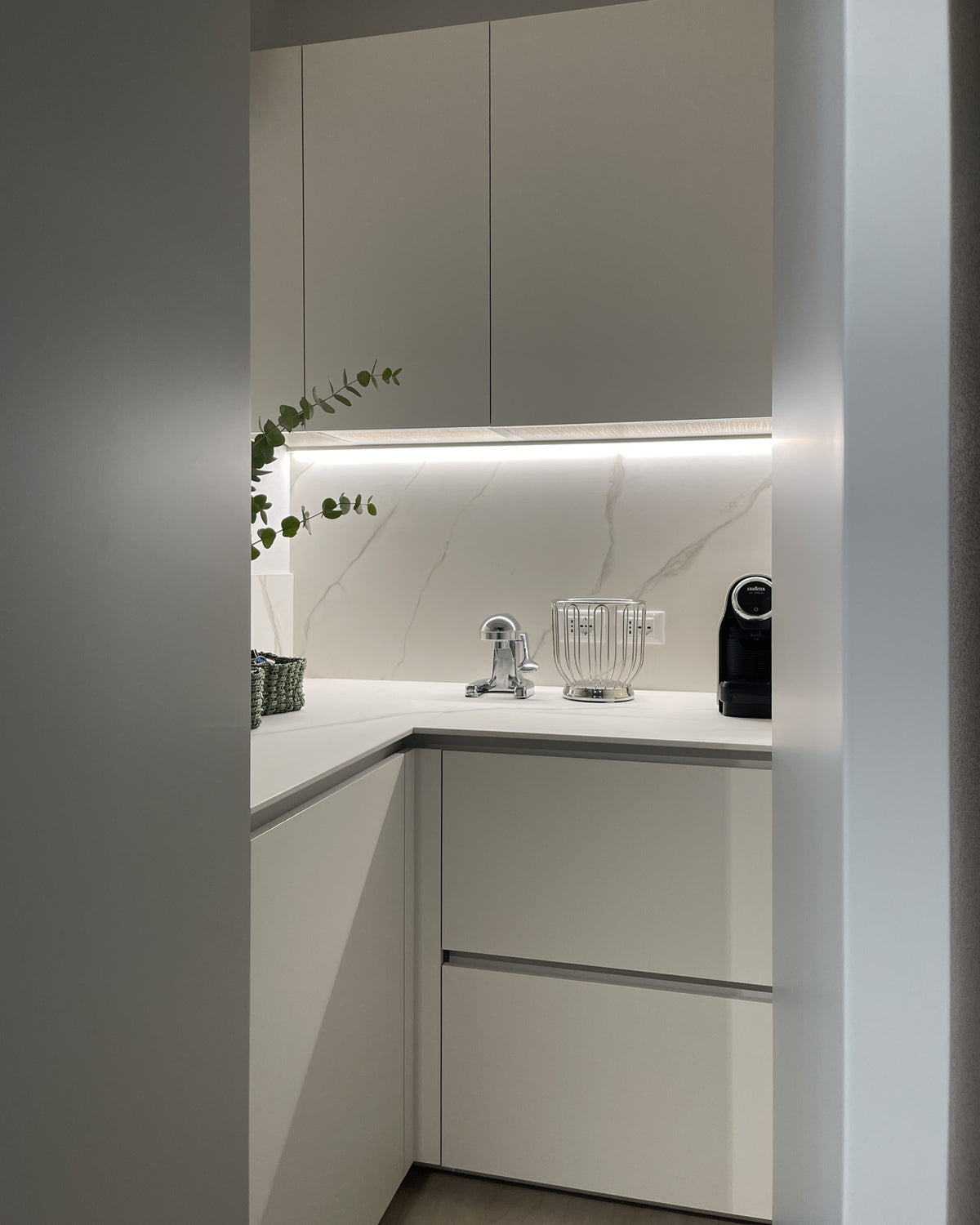 Dispensa nascosta integrata nella cucina su misura con piano di lavoro, contenitori e piccoli elettrodomestici