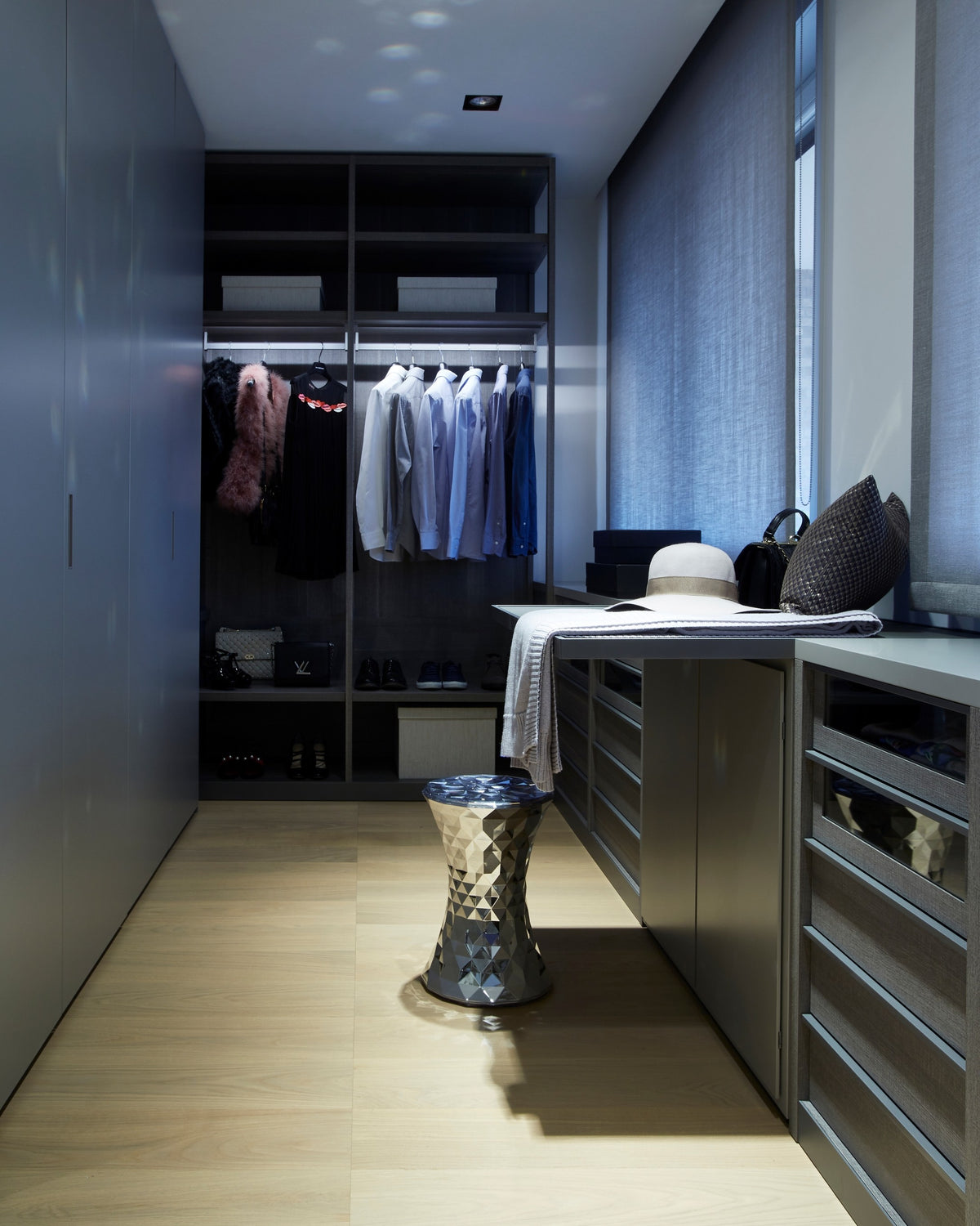 Dettaglio della cabina armadio moderna con illuminazione integrata, cassettiere, armadiatura a tutta altezza e armadio a giorno