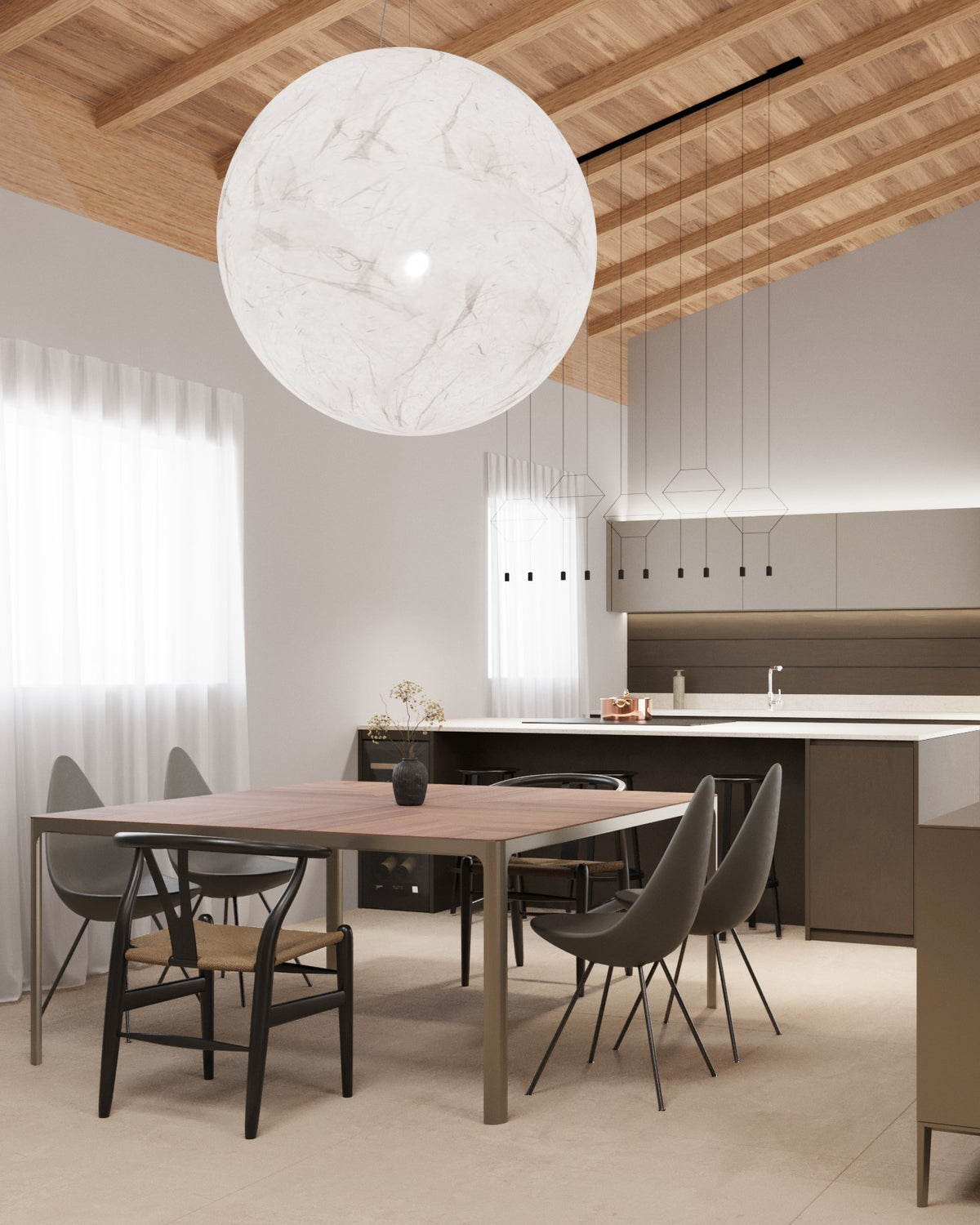 Dettaglio di cucina con isola e zona pranzo in open space contemporaneo con soffitto a travi in legno a vista e grande sospensione sferica Moon